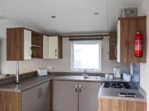 a kitchen with a sink and a fire extinguisher at Birch 1 - Ukc8214 in Pendine