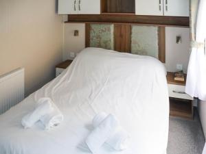 a bed with white sheets and towels on it at Birch 1 - Ukc8214 in Pendine