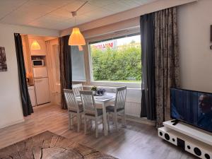 a dining room with a table and chairs and a television at Hamina Comfort Apartment in Hamina