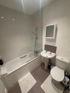 a bathroom with a toilet and a sink and a shower at Home from Home 1 in Castleford +9 photos
