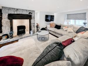 a living room with a couch and a fireplace at Mill House - Uk50646 in Falmouth