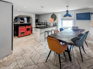 a kitchen with a wooden table and chairs in a room at Mill House - Uk50646 in Falmouth