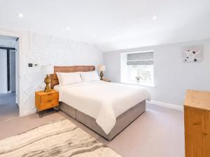 a white bedroom with a large bed and a window at Mill House - Uk50646 in Falmouth