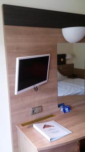 a desk with a tv on top of a bed at Hotel Bergfrieden in Bad Wildbad