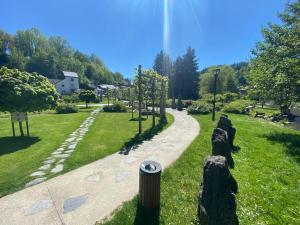 a path in a park with trees and a house at Les Variétés in La-Roche-en-Ardenne