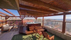 a large deck with a hot tub on a roof at Gador Sea View in H̱adera +19 photos