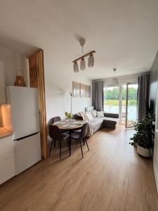 a living room with a table and a refrigerator at Marigold Apartment Łódź in Łódź