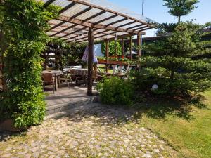 a wooden pergola in a garden with a table and chairs at pinocchio pirow in Pirow