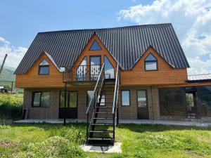 a house with a metal roof and a staircase at Casa KamArea in Kazbegi +25 photos