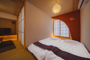 a bedroom with a large bed with a window at ヒカリとテラス in Nagano