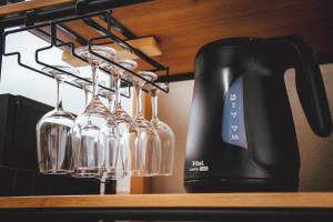 a coffee maker and wine glasses hanging from a rack at ヒカリとテラス in Nagano