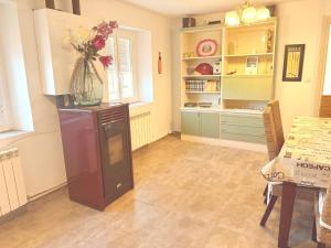 a kitchen with a table and a vase of flowers on a refrigerator at San Millán 1 in Soria