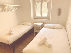 two twin beds in a room with a window at San Millán 1 in Soria