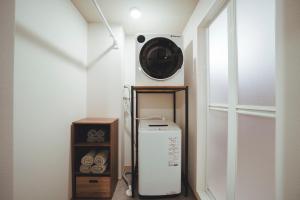 a laundry room with a washing machine and a window at ヒカリとテラス in Nagano