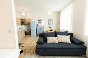 a living room with a blue couch and a kitchen at Atelier Lion in Žďár nad Sázavou