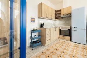 a kitchen with wooden cabinets and a white refrigerator at Atelier Lion in Žďár nad Sázavou +10 photos
