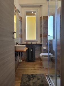 a bathroom with a toilet and a sink and a mirror at The Blue Gem in Acqui Terme +3 photos