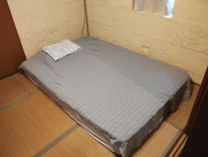 a small bed in a corner of a room at Unwind DAY OFF Nagamo in Yaese