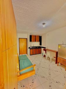 a living room with a bed and a kitchen at Casa Vacanza Apartamentos in Leticia