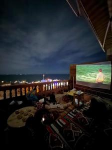 a group of people watching a movie on a large screen at Ocean Nomads hostel Taghazout in Taghazout