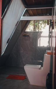 a bathroom with a toilet and a window at Cabana dos sonhos Chalé experience Hidro CinemaSPA in Mateus Leme +82 photos