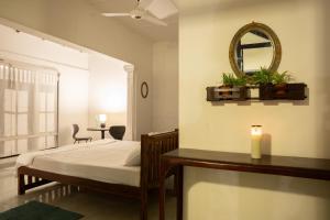 a bedroom with a bed and a mirror and a table at Aviyan Villa Wadduwa in Wadduwa