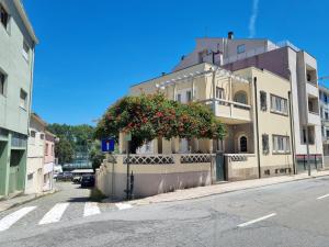 a building with a flowering tree on the side of a street at Luna Navegante in Porto