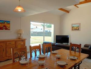 a living room with a wooden table and chairs at Villa l Albatros - Coex in Coëx