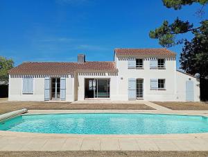 a house with a swimming pool in front of a house at Villa l Albatros - Coex in Coëx