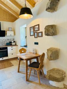 a kitchen with a wooden table and a chair at Ferienhaus Steinschlössl in Mühldorf +34 photos