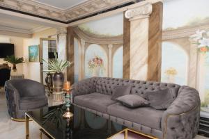 a living room with a couch and a painting at Alessio Hotel Residence in Costinesti