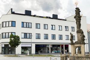 a white building with a statue in front of it at Atelier Lion in Žďár nad Sázavou