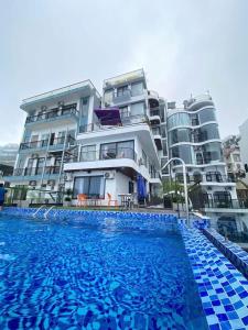 a swimming pool in front of a large building at Time Villa in Tam Ðảo