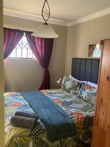 a bedroom with a bed and a window at Cave view Cottages in Muldersdrift