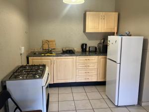 a kitchen with a white refrigerator and a stove at Cave view Cottages in Muldersdrift