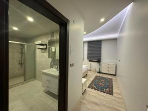 a bathroom with a shower and a sink and a mirror at Göreme Apartment in Göreme +18 photos