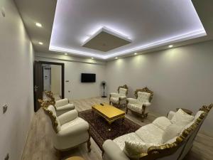 a living room with white furniture and a tv at Göreme Apartment in Göreme