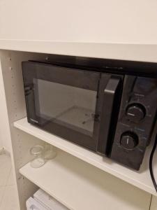 a microwave oven sitting on a shelf in a kitchen at Apartment in Salerno Centro in Salerno