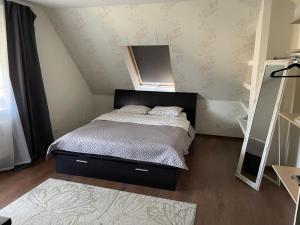 a small bedroom with a bed in a attic at Svetes house - Garden & BBQ & Parking in Liepāja