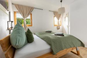 a bedroom with a bed with green blankets and pillows at Wildstein - Ferienwohnungen in Bayrischzell