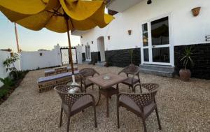 a patio with a table and chairs and an umbrella at Villa Mena Luxor in Luxor