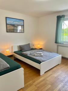 a bedroom with a white bed and a window at Ferienwohnung Adelsried 1 in Adelsried