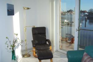 Una sala de estar con una silla y una ventana. en Marina 68/70, en Cuxhaven