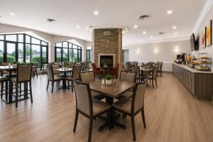 a dining room with tables and chairs and a fireplace at Quality Inn and Conference Centre in Pembroke