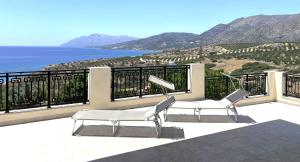 two chairs on a balcony with a view of the ocean at Blue Coast - Seaside Apartment in Keratokampos