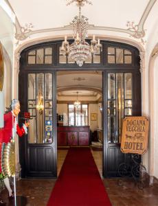 a woman standing in front of a door with a red carpet at Hotel Antica Dogana in Turin