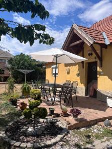 a patio with a table and an umbrella at BLTN House in Balatonalmádi