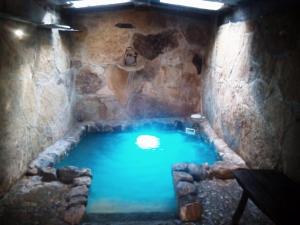 a large pool of blue water in a stone cave at Hotel Rural Bermellar in Bermellar