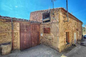 an old stone building with a wooden door at Hotel Rural Bermellar in Bermellar +21 photos
