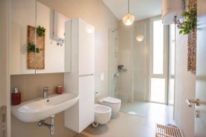 a white bathroom with a sink and a toilet at Enjoy Palasa Comfy Villas in Palasë +57 photos